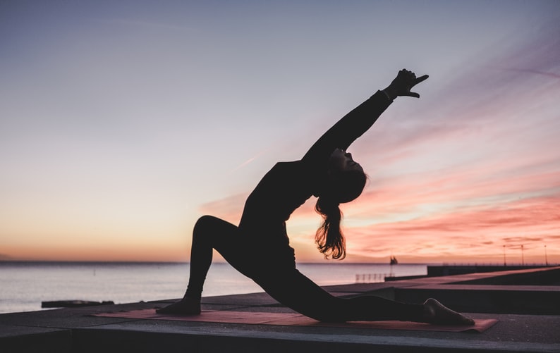 Person doing yoga at sunset