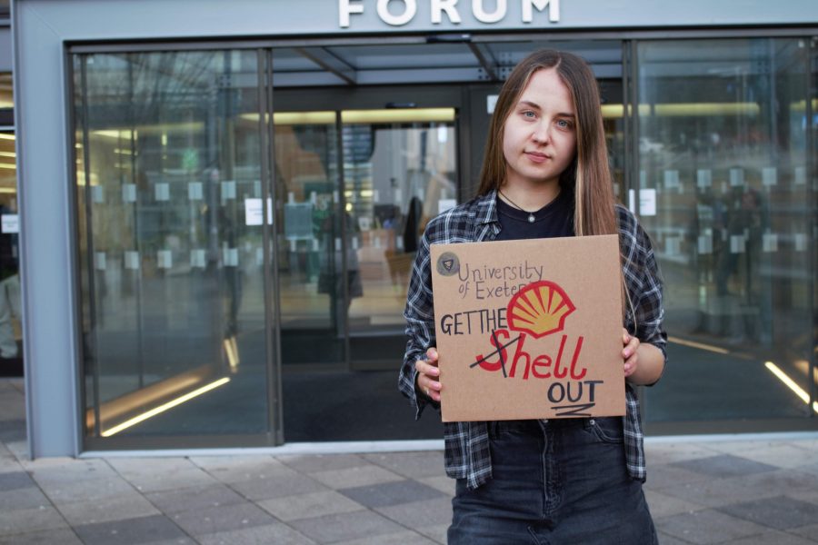 Emma de Saram, VP Liberation & Equality, holding a sign that says "University of Exeter, get the (S)hell out"