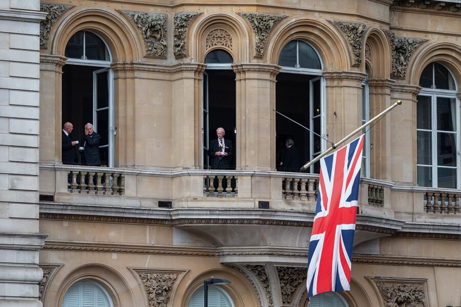 Building with King Charles stood in window and British flag draping